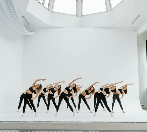 Group of diverse athletes practicing yoga together in a modern studio.